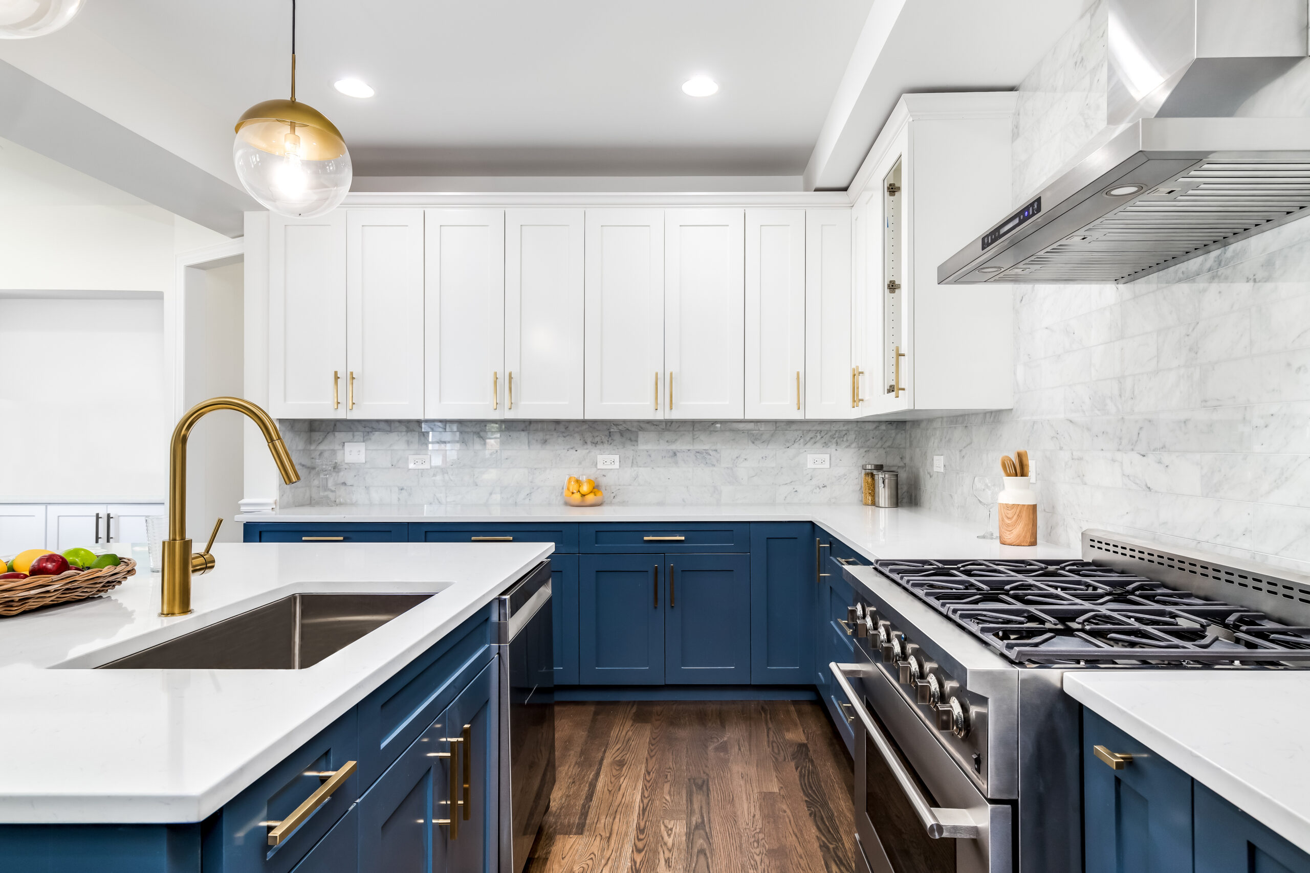 A luxurious white and blue kitchen with gold hardware, stainless steel appliances, and white marbled granite countertops. No brands or labels. Property Inspections in Bedford, NH